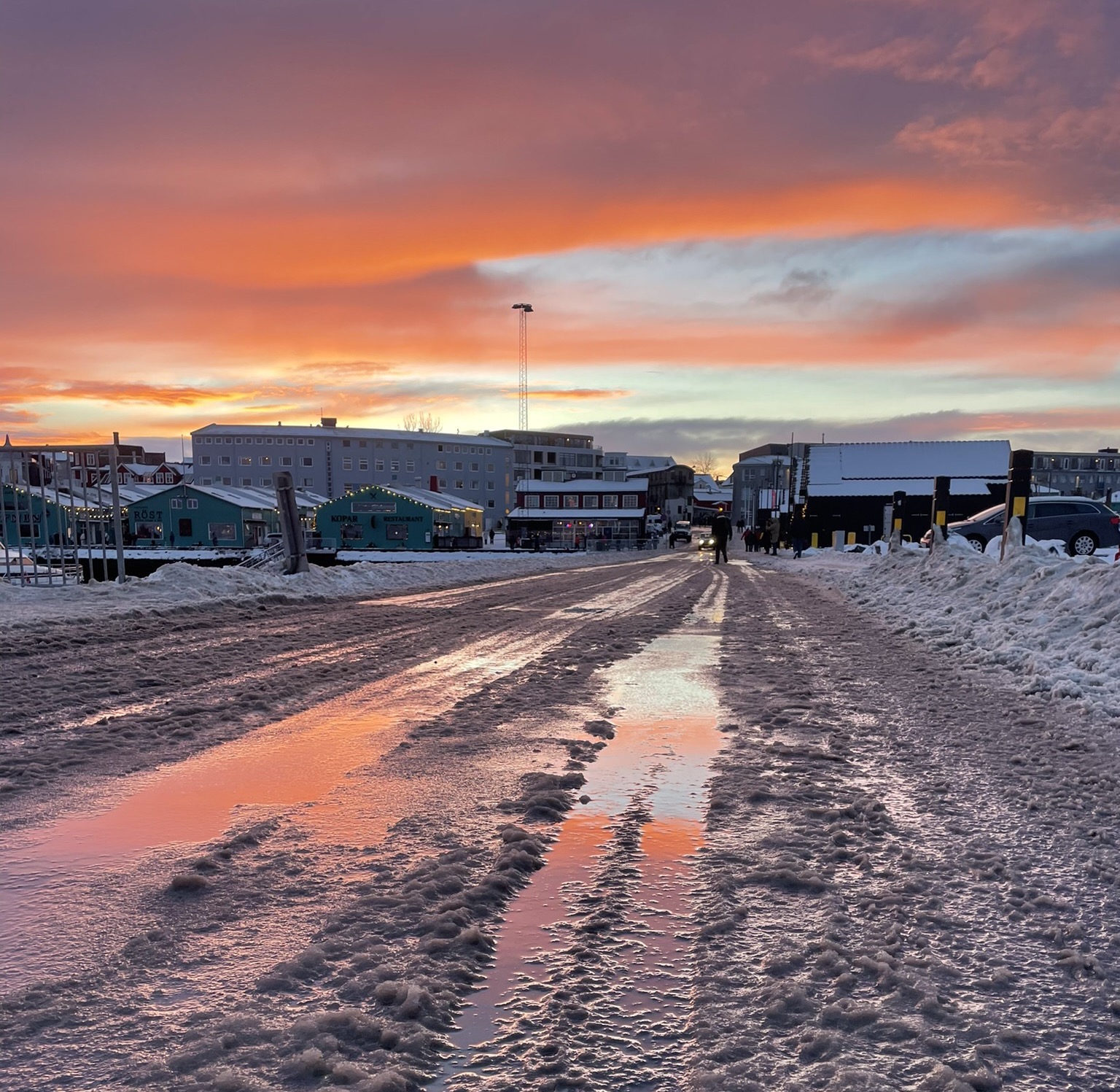 Tramonto spettacolare su una strada innevata in prossimità del porto