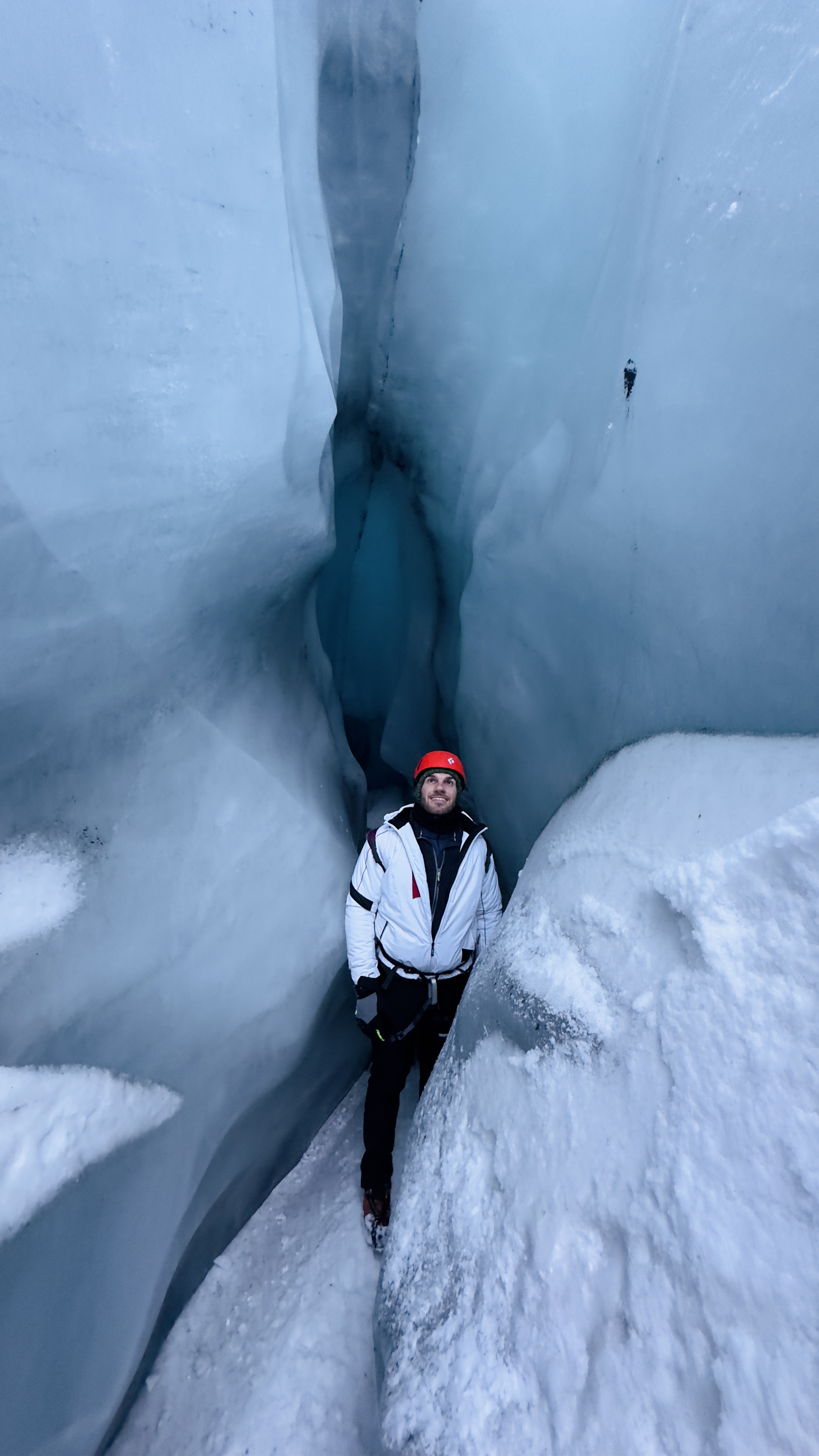 Esploratore posizionato tra strette pareti di ghiaccio vivo