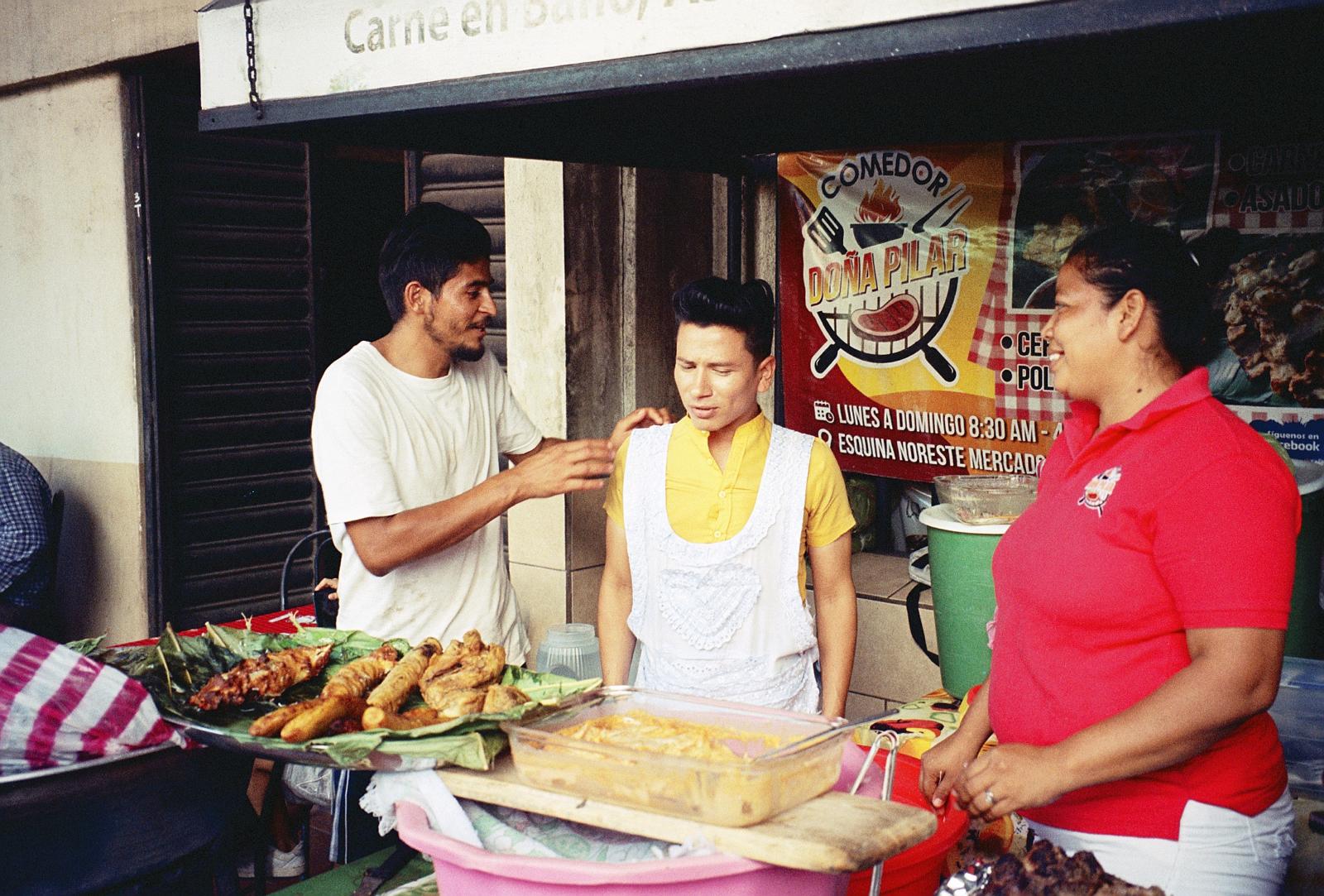 Persone al lavoro presso un banchetto di street food a León