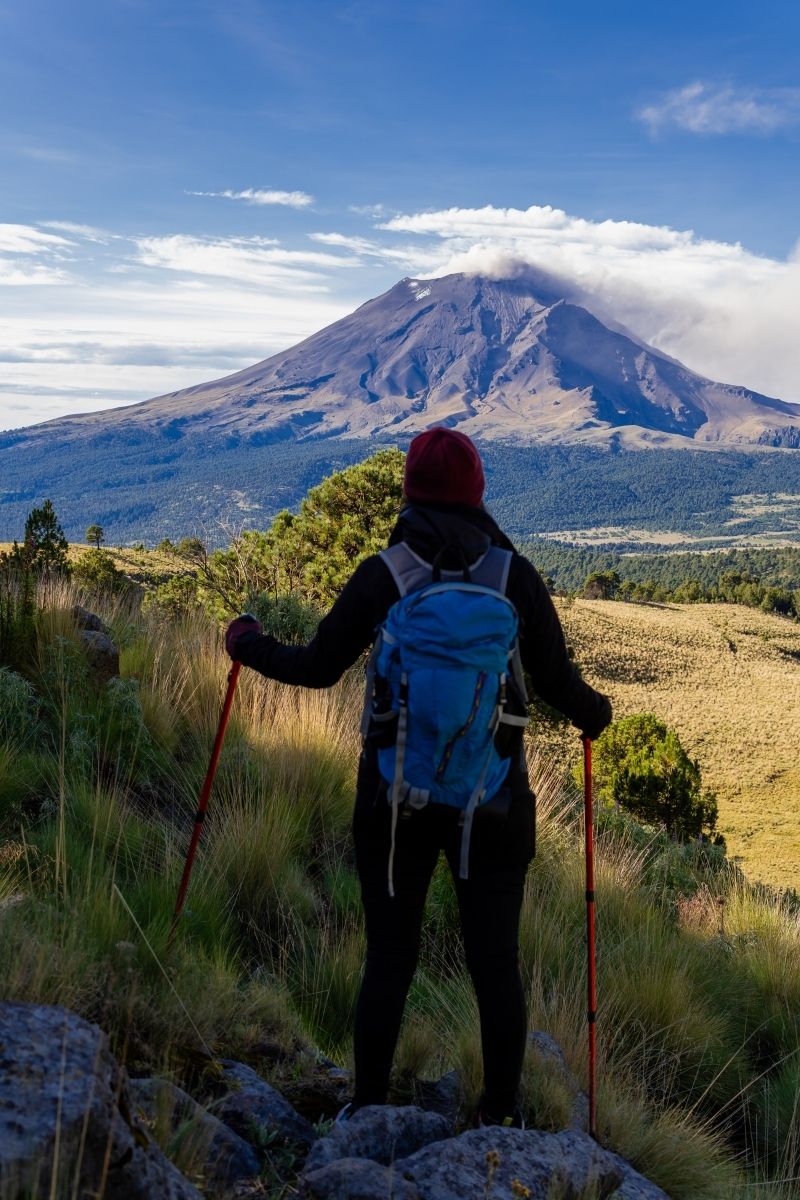 Escursionista guarda un vulcano, viaggiare post-covid