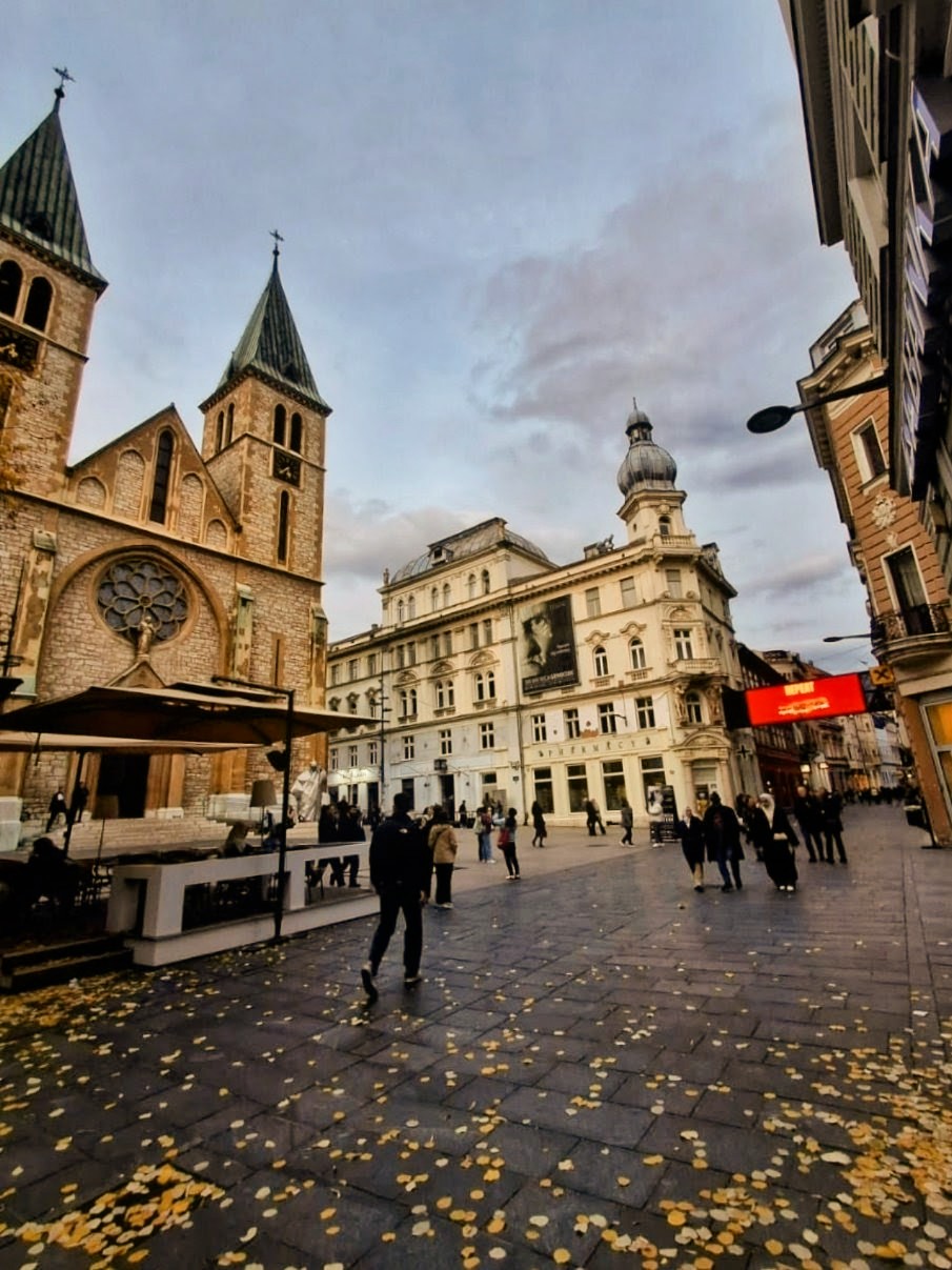 Vista serale dell'area pedonale contemporanea di Sarajevo con la cattedrale e persone che passeggiano