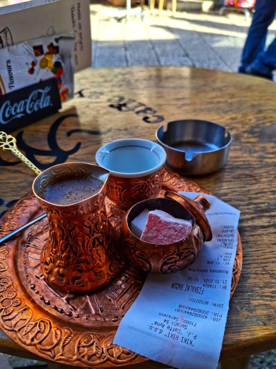 Servizio tradizionale di caffè bosniaco in recipienti di rame su un vassoio con dolce e scontrino