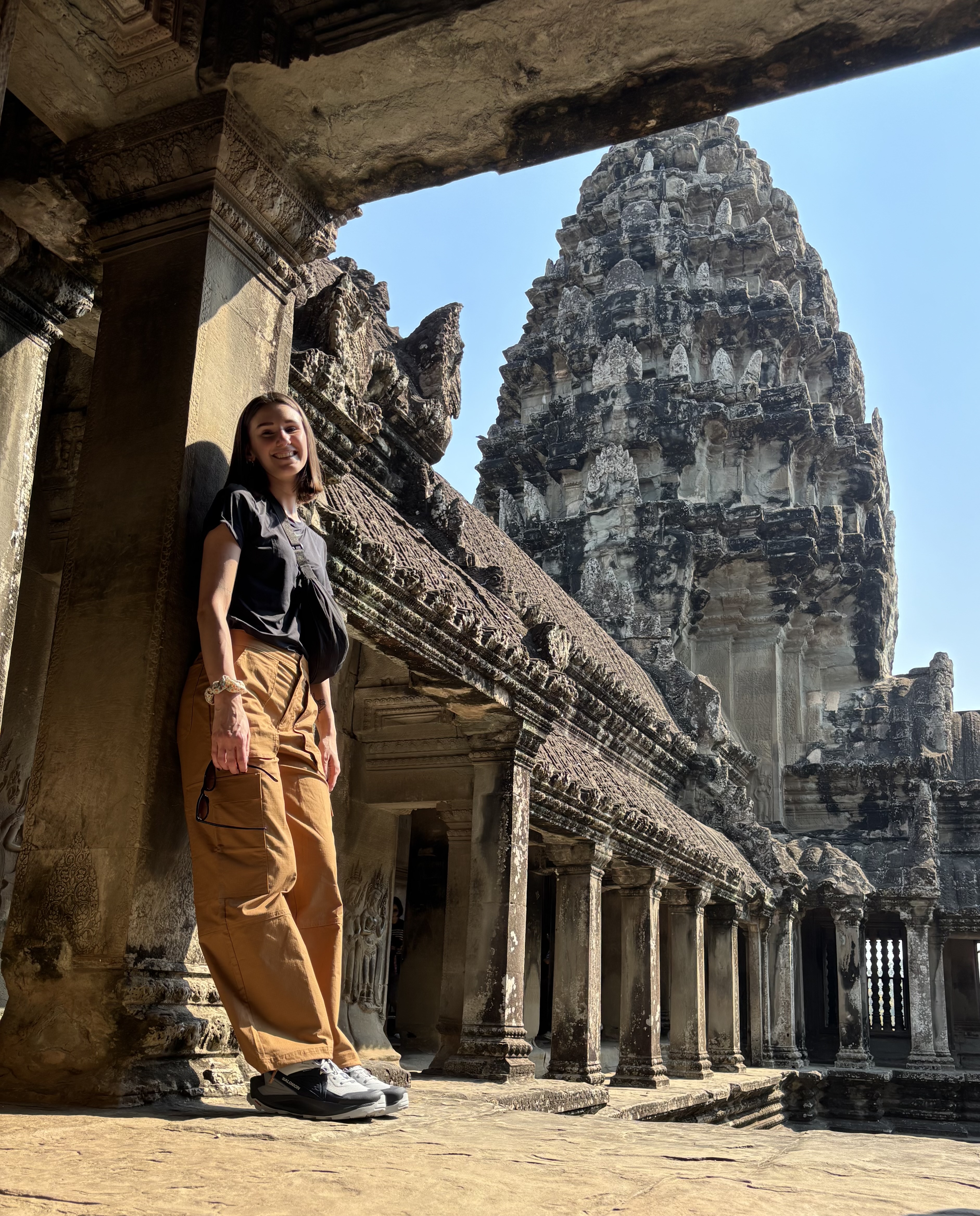 Alissia appoggiata ad una colonna secolare esplorando le rovine di Angkor Wat