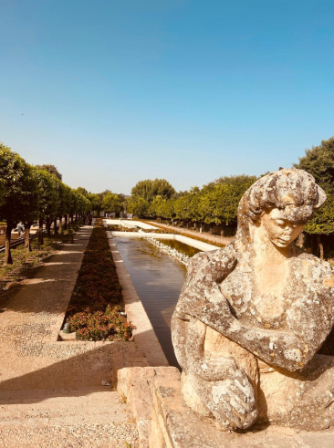 Primo piano di una statua in pietra classica all'interno del Giardino dell'Alcázar de los Reyes Cristianos a Córdoba, tra viali siepati