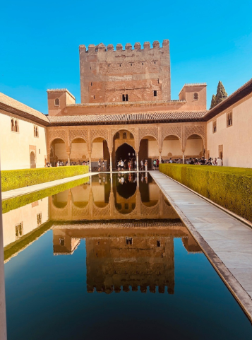 L'iconico Patio de los Arrayanes all'interno dell'Alhambra di Granada, con la sua lunga vasca d'acqua che riflette l'architettura circostante