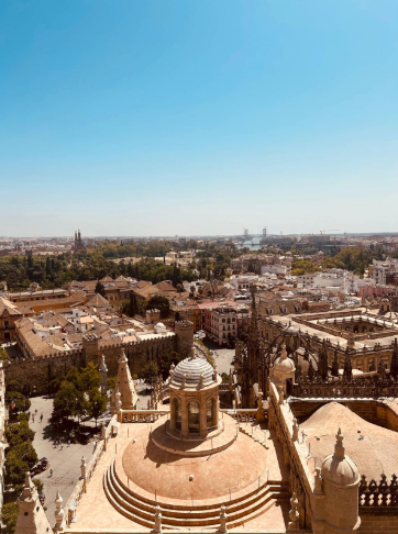 Emanuela Macciocca travel designer guarda Siviglia dai tetti della Cattedrale e dalla Giralda, con vista sulla cupola, sulla Torre del Oro e sul fiume Guadalquivir