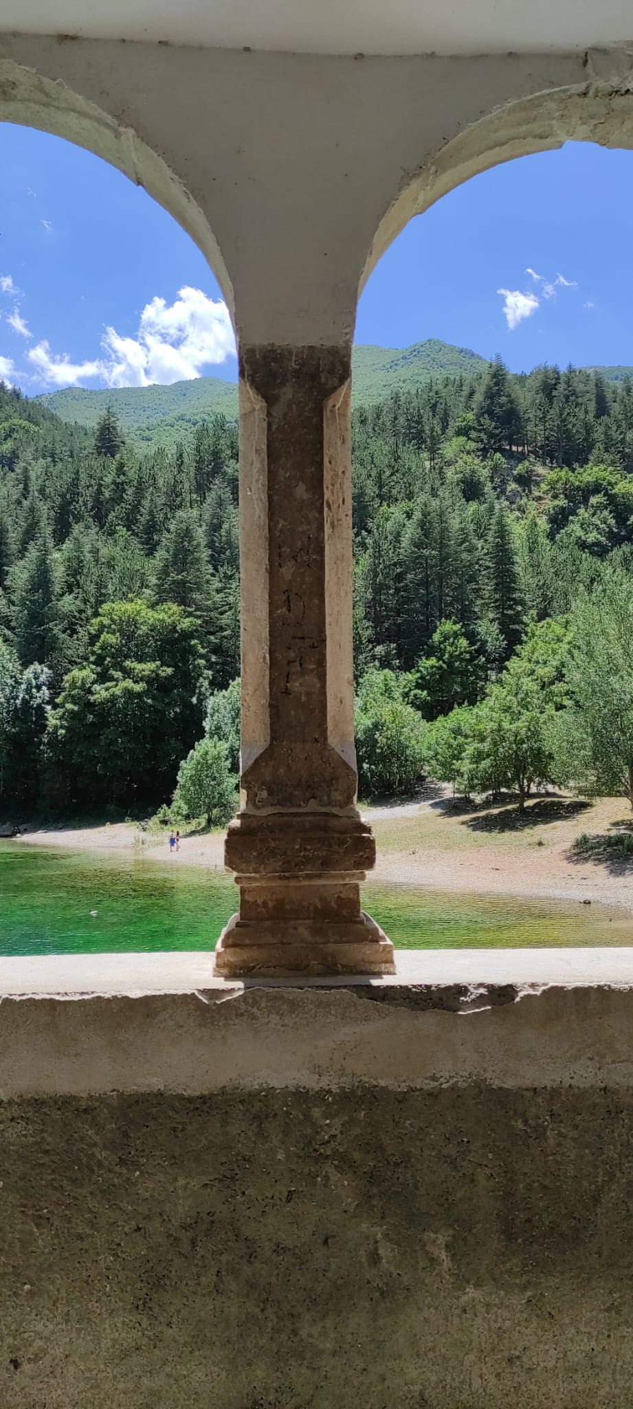 Meraviglioso scorcio paesaggistico del fiume dalle sfumature smeraldo incorniciato da un porticato storico in pietra