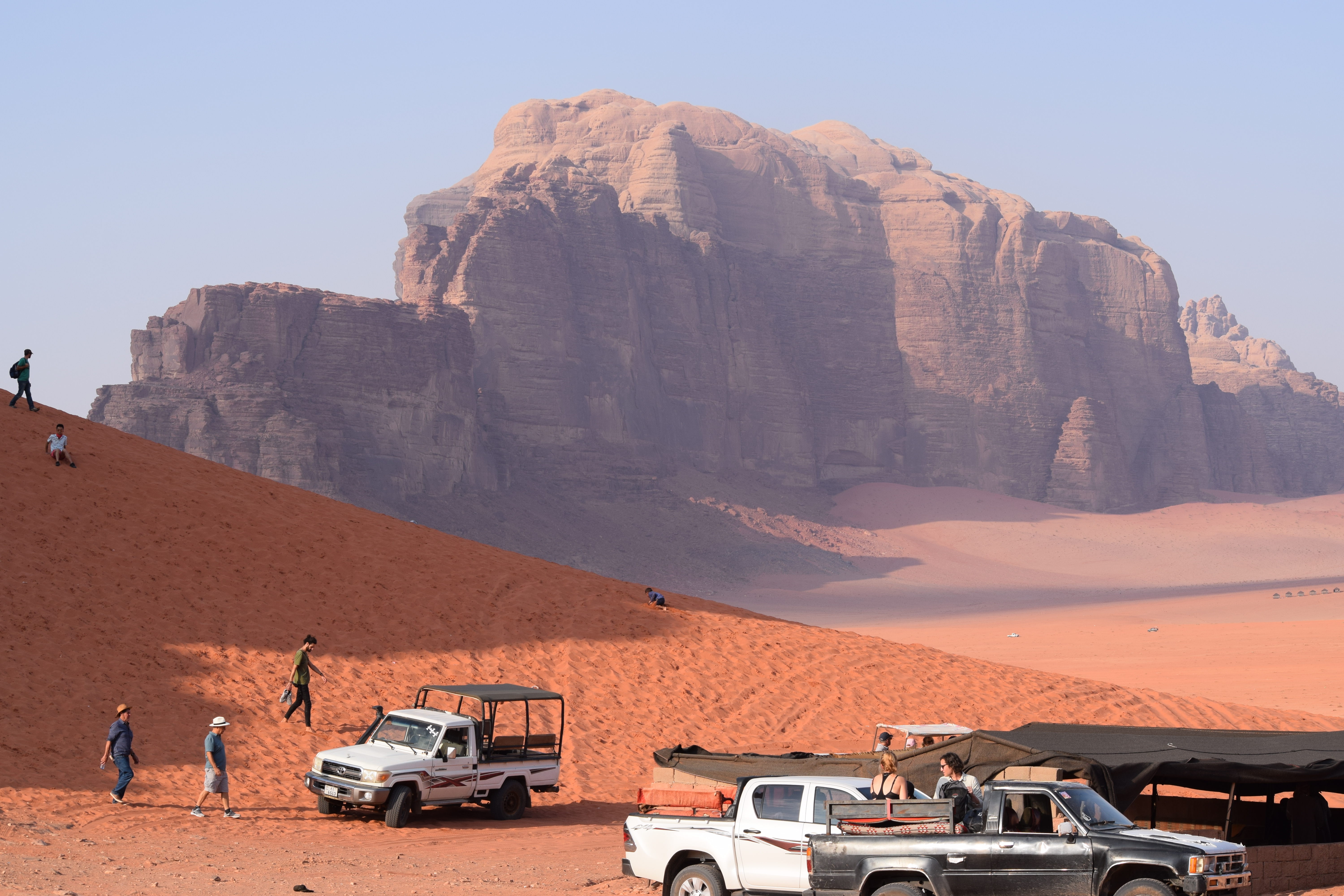 Persone che fanno sandboarding sulle dune rosse del Wadi Rum
