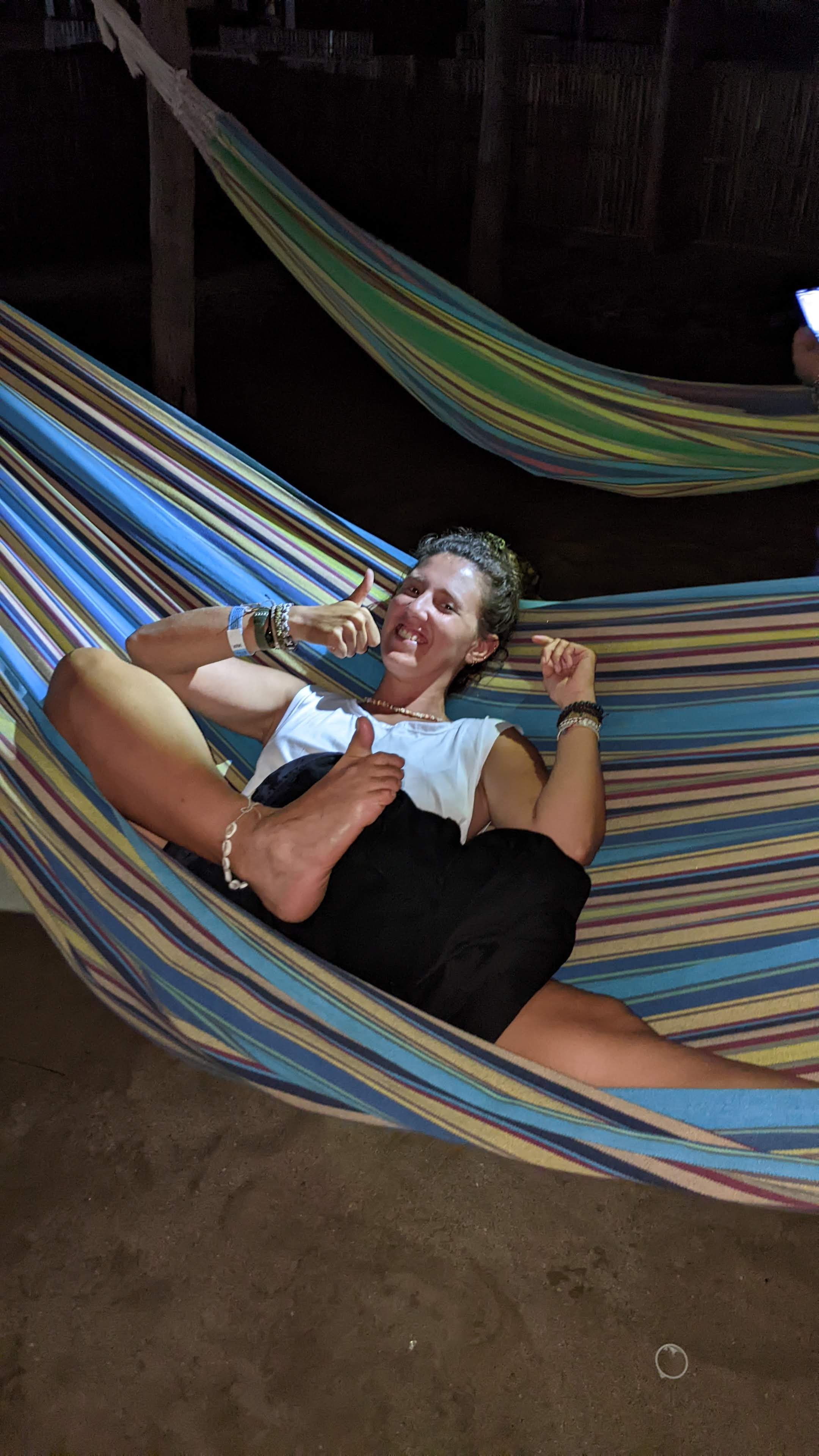 Ragazza sorridente che si rilassa in un'amaca colorata