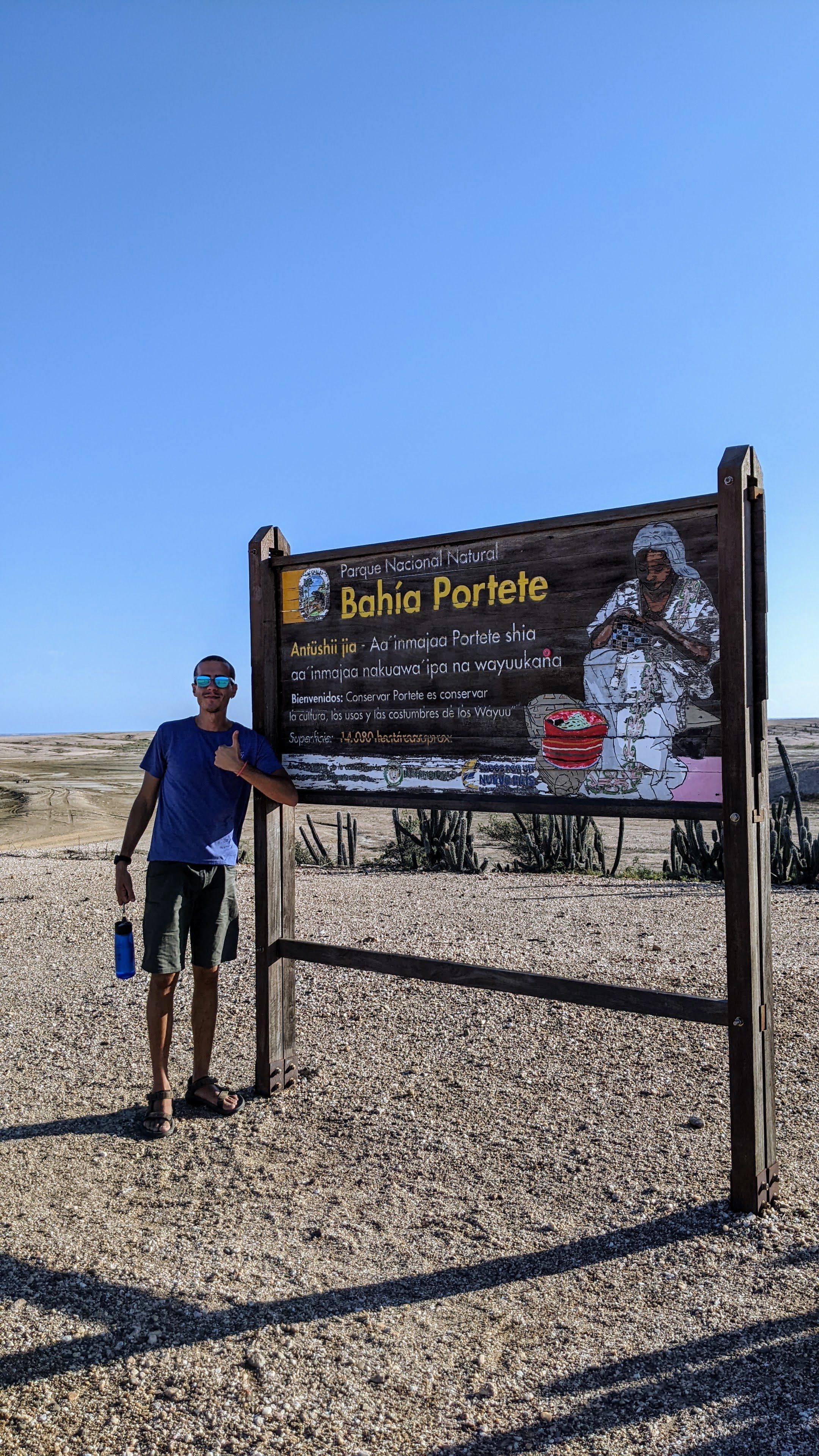 Ragazzo in posa davanti al cartello del Parque Nacional Natural Bahia Portete