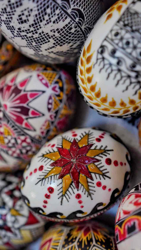 Uova pasquali tradizionali romene decorate a mano con motivi geometrici e floreali in colori vivaci, tipiche dell’arte popolare della Bucovina.